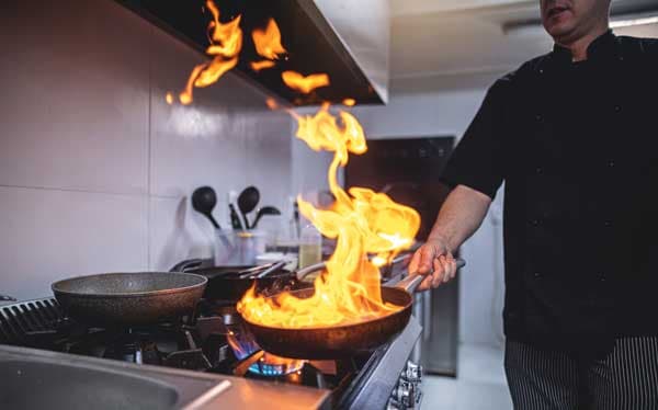 Chef cooking under a commercial hood in Los Angeles