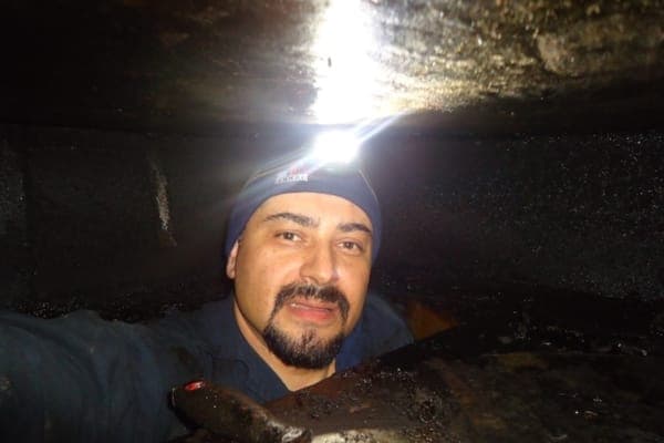 Exhaust hood cleaner working inside a grease duct
