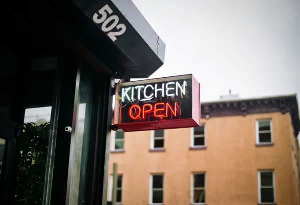 Kitchen Open neon sign outside a restaurant