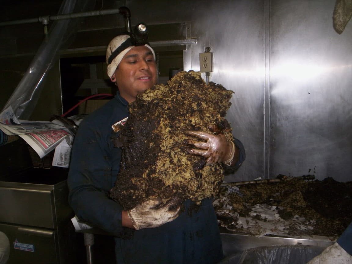 Bryan Exhaust technician holding a slab of grease removed from a kitchen exhaust system